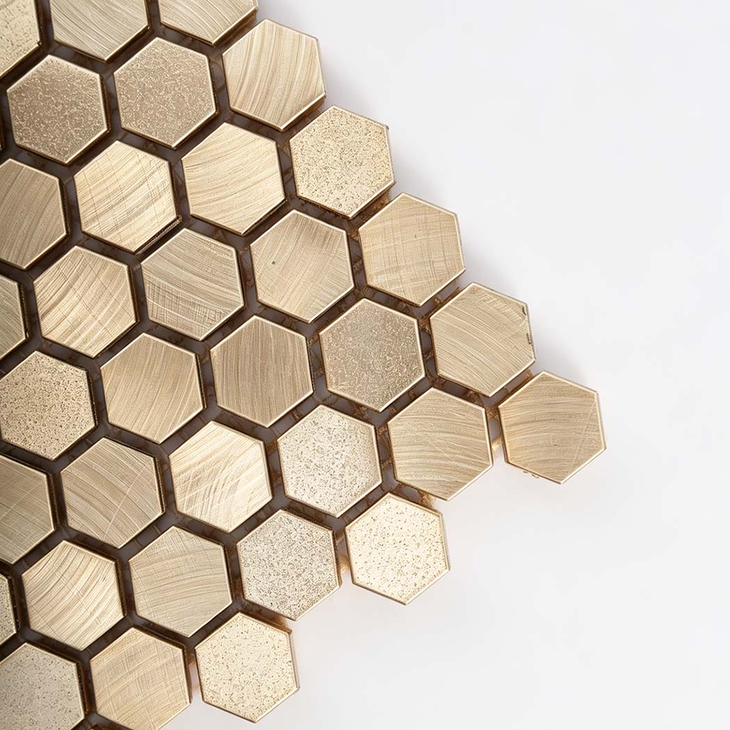 Corner view of gold mini hexagon tile with brushed and stippled texture