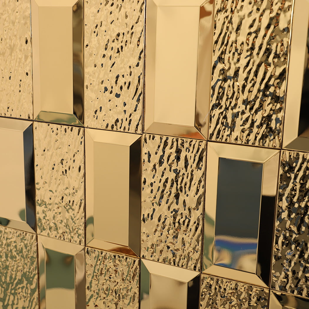 Angled side view of gold mirror mosaic wall showing light reflection.