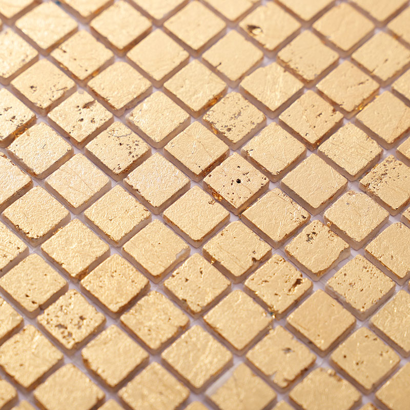 Close-up of gold mosaic tile sheet with small square tiles and subtle texture