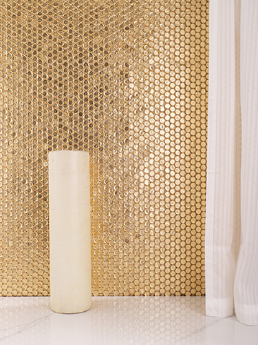 A close-up of a golden mosaic wall with a smooth, shiny surface.