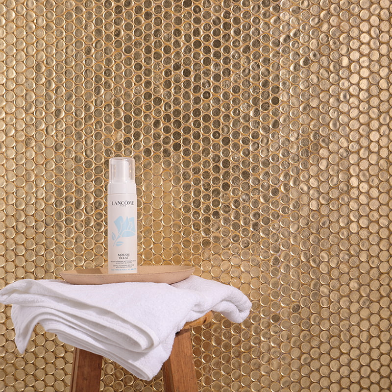 Golden mosaic tile wall with beauty products 