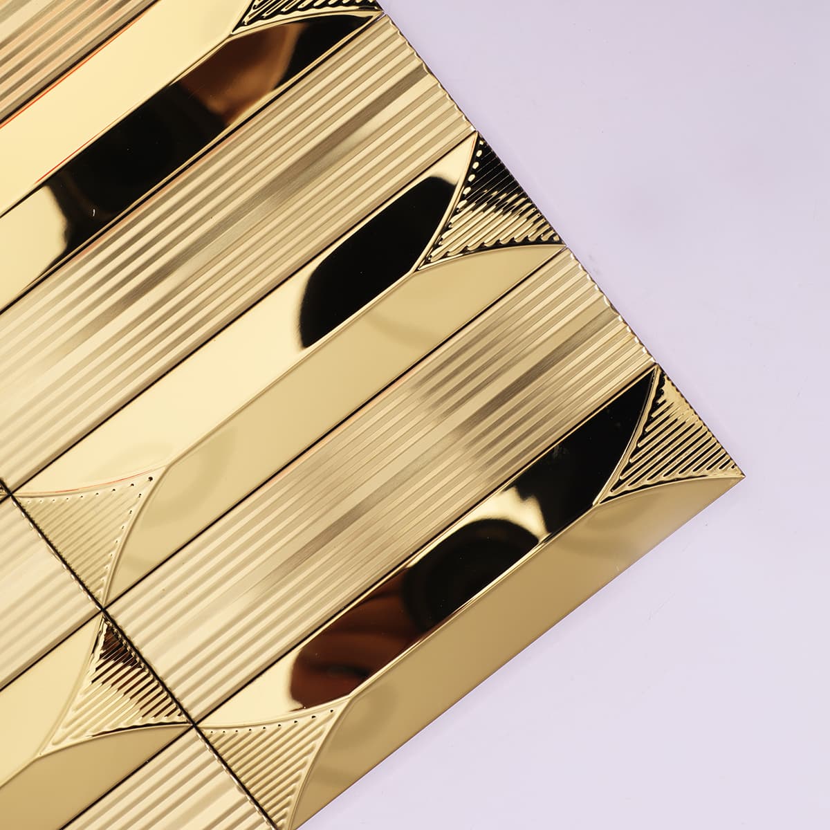 Close-up of gold stainless mosaic corner showing mirror shine and ridges
