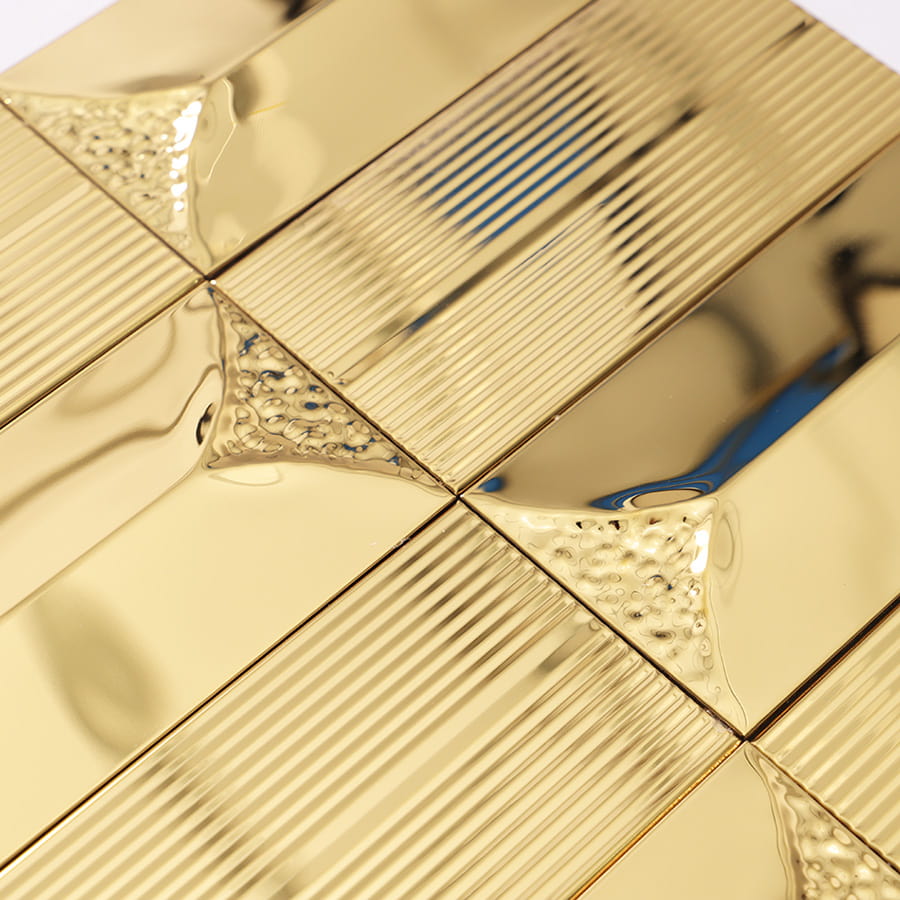 Close-up of gold stainless steel decorative wall tile showing reflective finish and pattern.