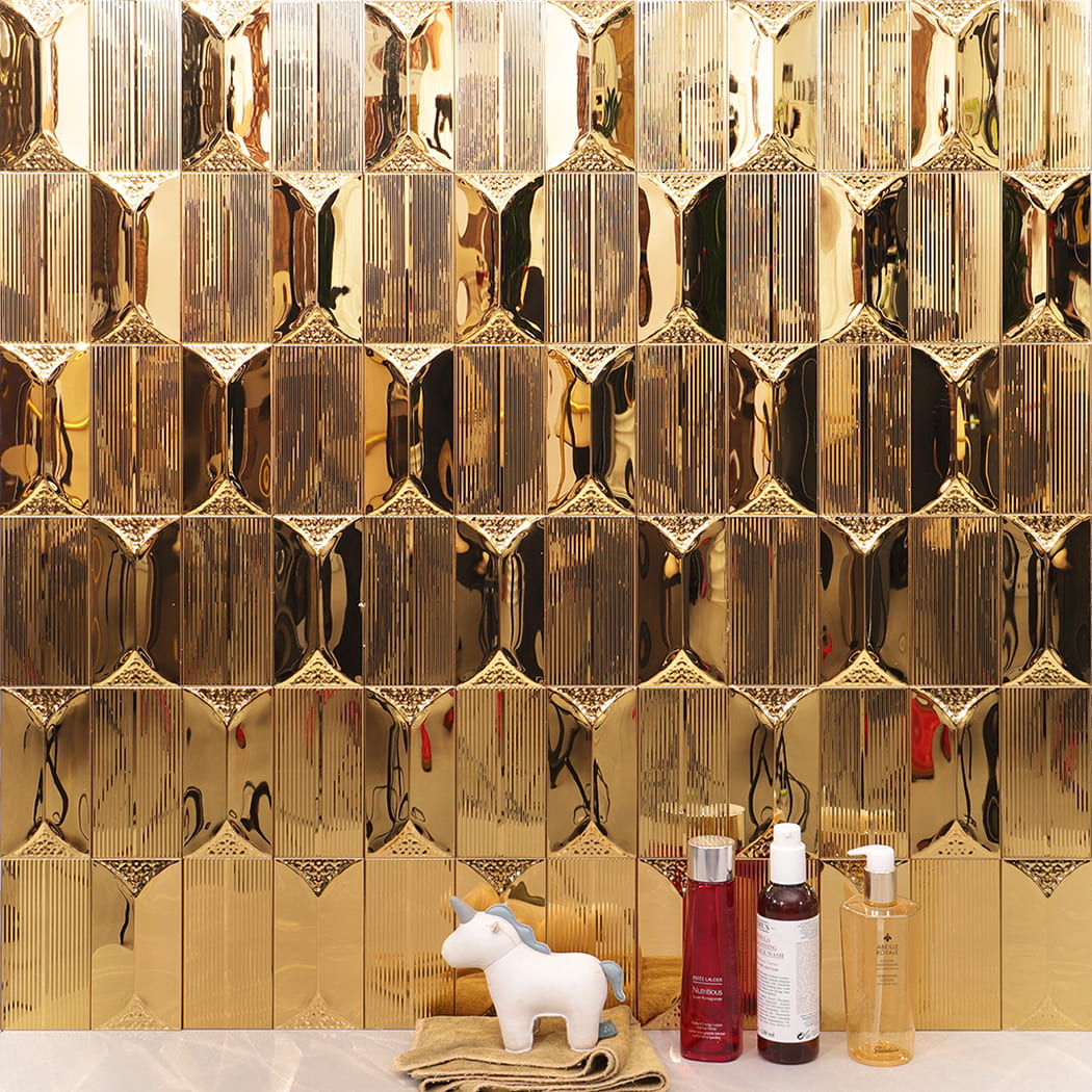 Gold stainless steel wall tile used in bathroom setting with decor items.