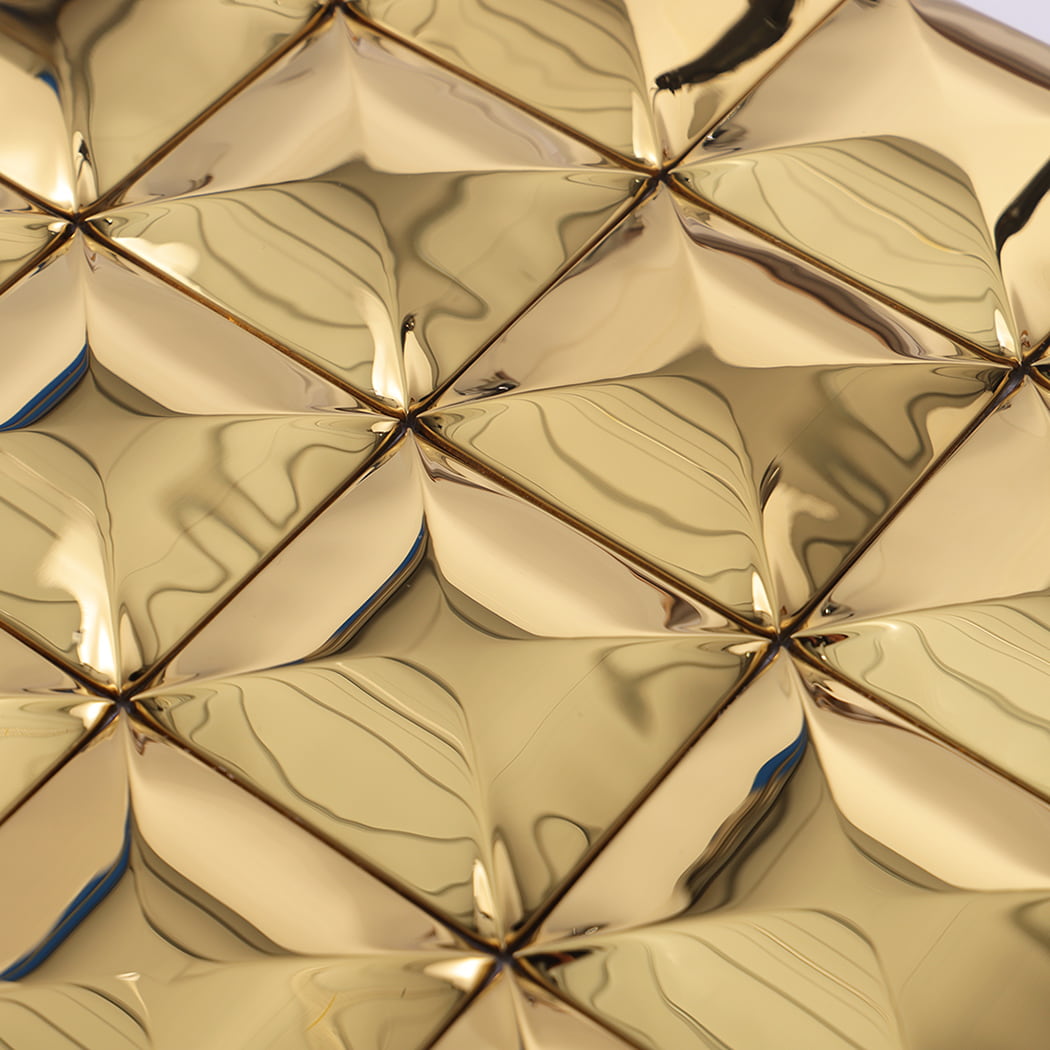 Close-up showing the reflective surface of gold stainless steel 3D square tiles.
