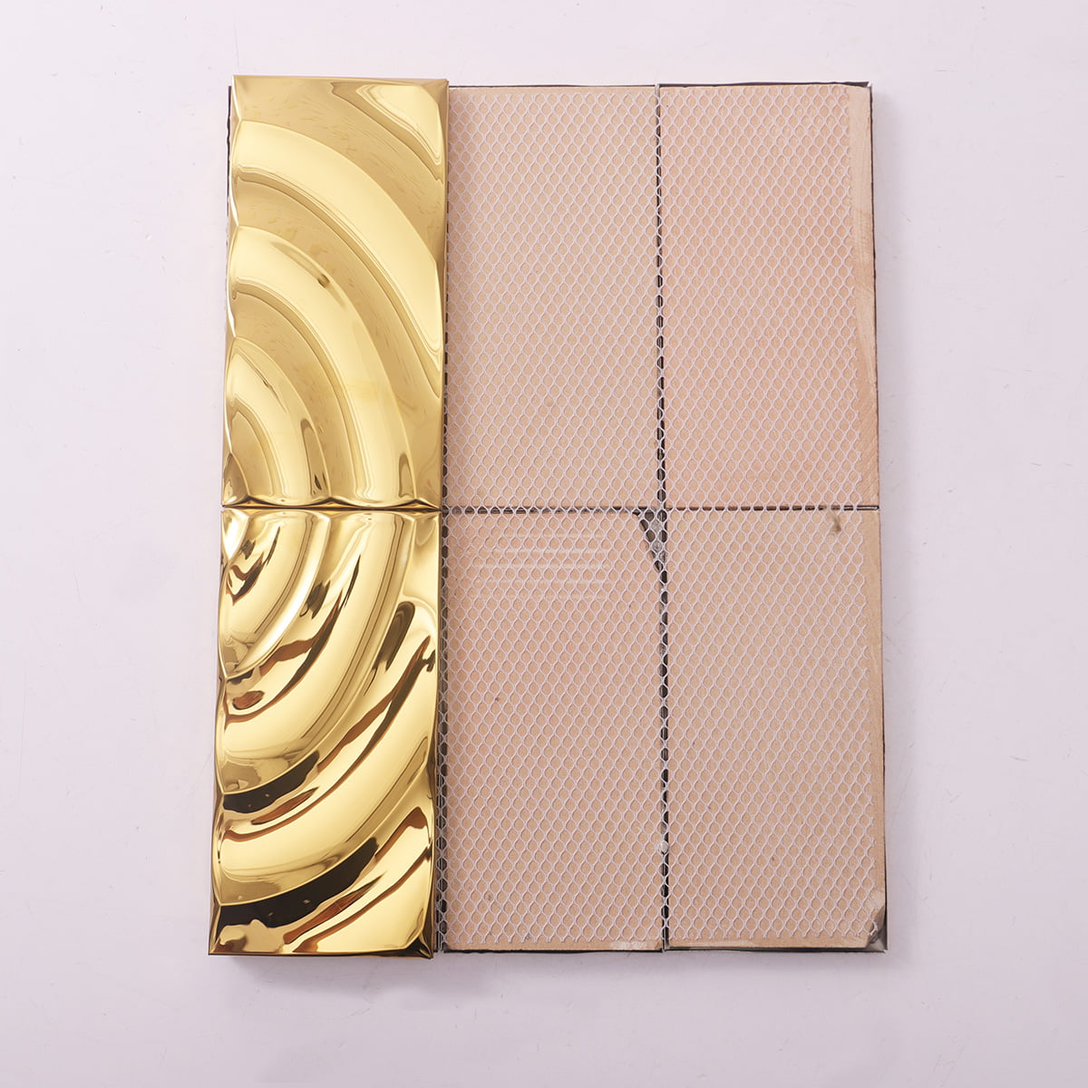 A gold wavy tile shown next to beige mesh backing for easy installation