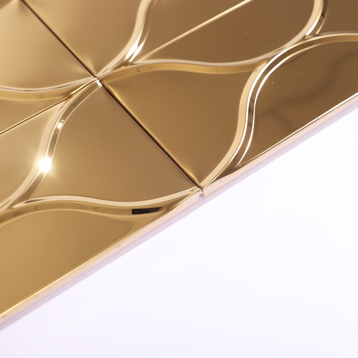 Edge detail of wave-shaped gold mosaic tile with light reflection