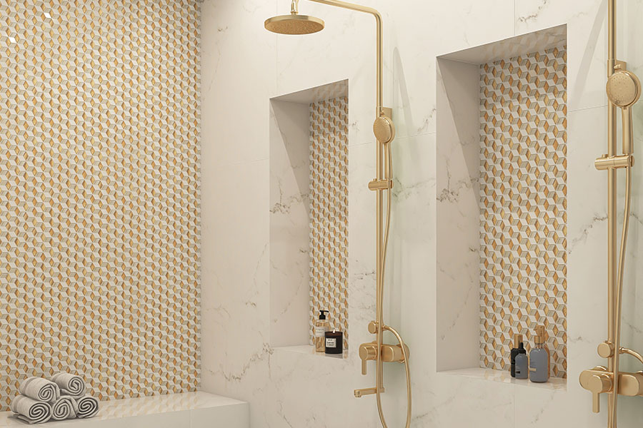 Gold and white geometric mosaic tile shower wall with recessed niches and brass fixtures