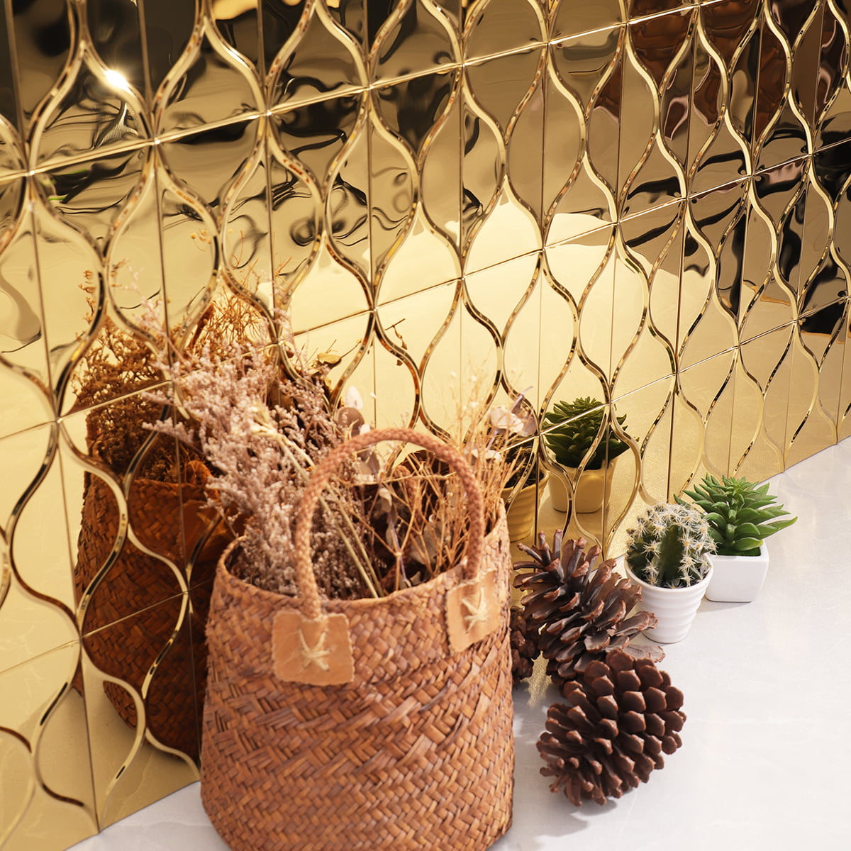 Close-up of a golden patterned tile wall with a basket and plants in the foreground