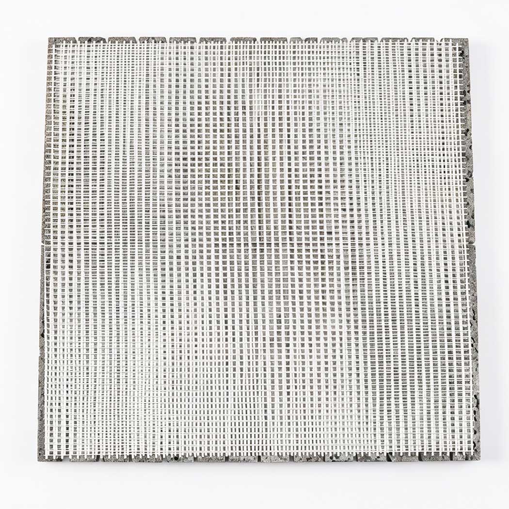 Back view of gray lava stone linear mosaic tile sheet with white mesh backing
