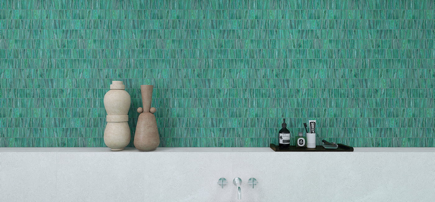 A bathroom wall with green glass tiles, decorative vases, and a modern sink. 