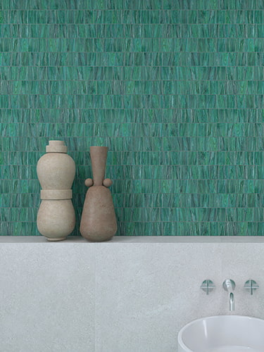 A close-up of a bathroom wall with green glass tiles and decorative vases.
