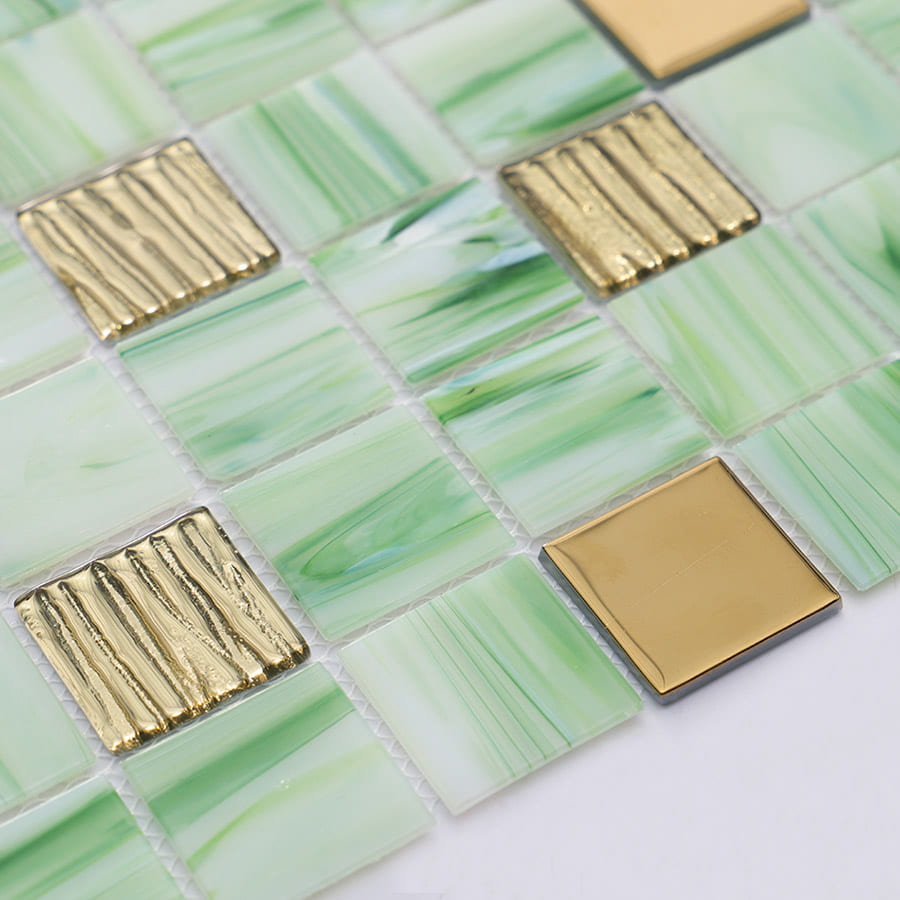 Angled view of green mosaic tile sheet with glossy gold accents