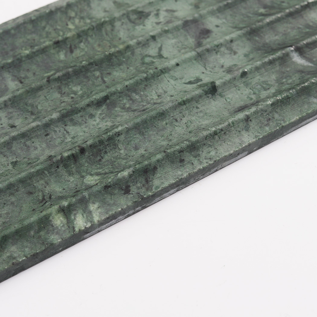 Close up of green marble fluted tile with layered dark stone texture