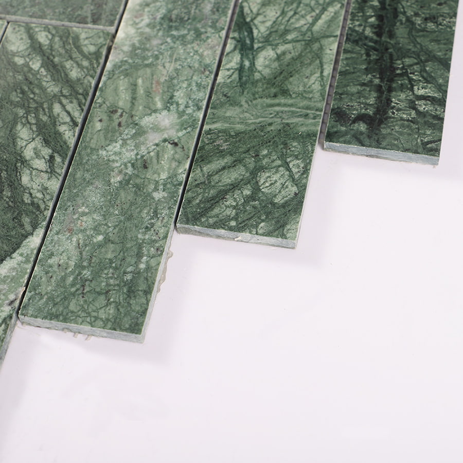 Edge close-up showing texture of green marble herringbone tile