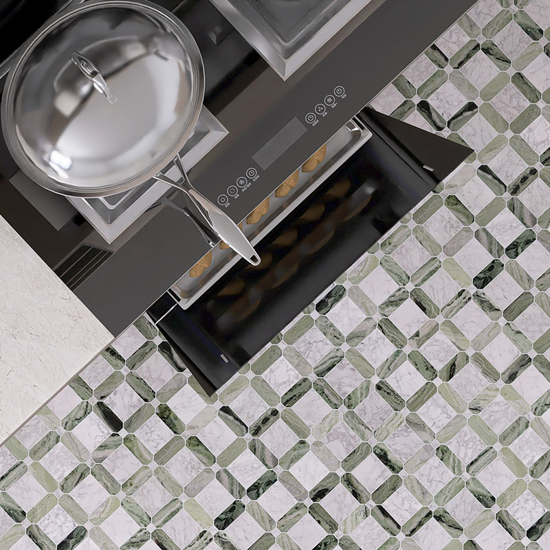 Close-up of green and white marble mosaic floor tile beside a kitchen stove