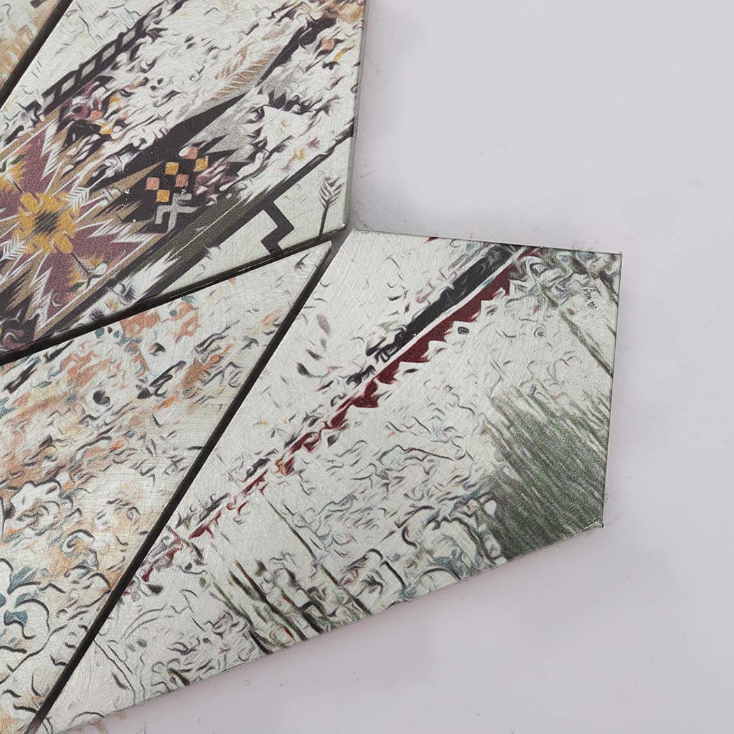Close-up of grey diamond shaped metal wall tiles with vintage patterns