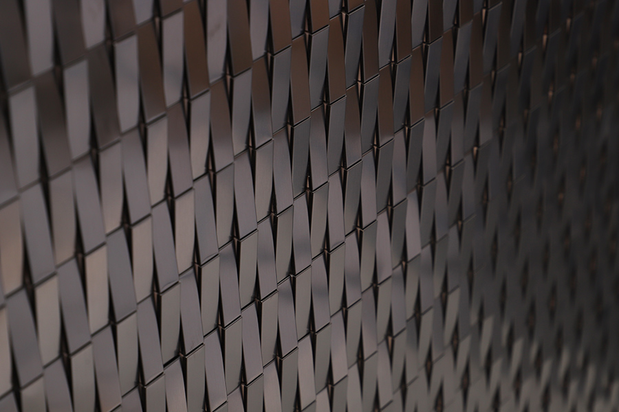Modern groutless tile backsplash featuring reflective metallic geometric design