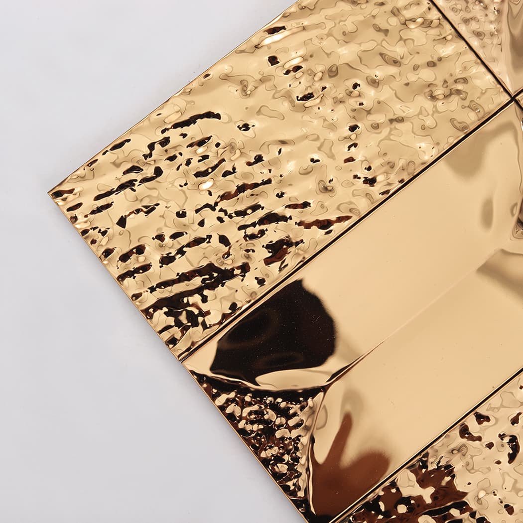 Close up of hammered and polished rose gold 3d metal tiles showing textures.
