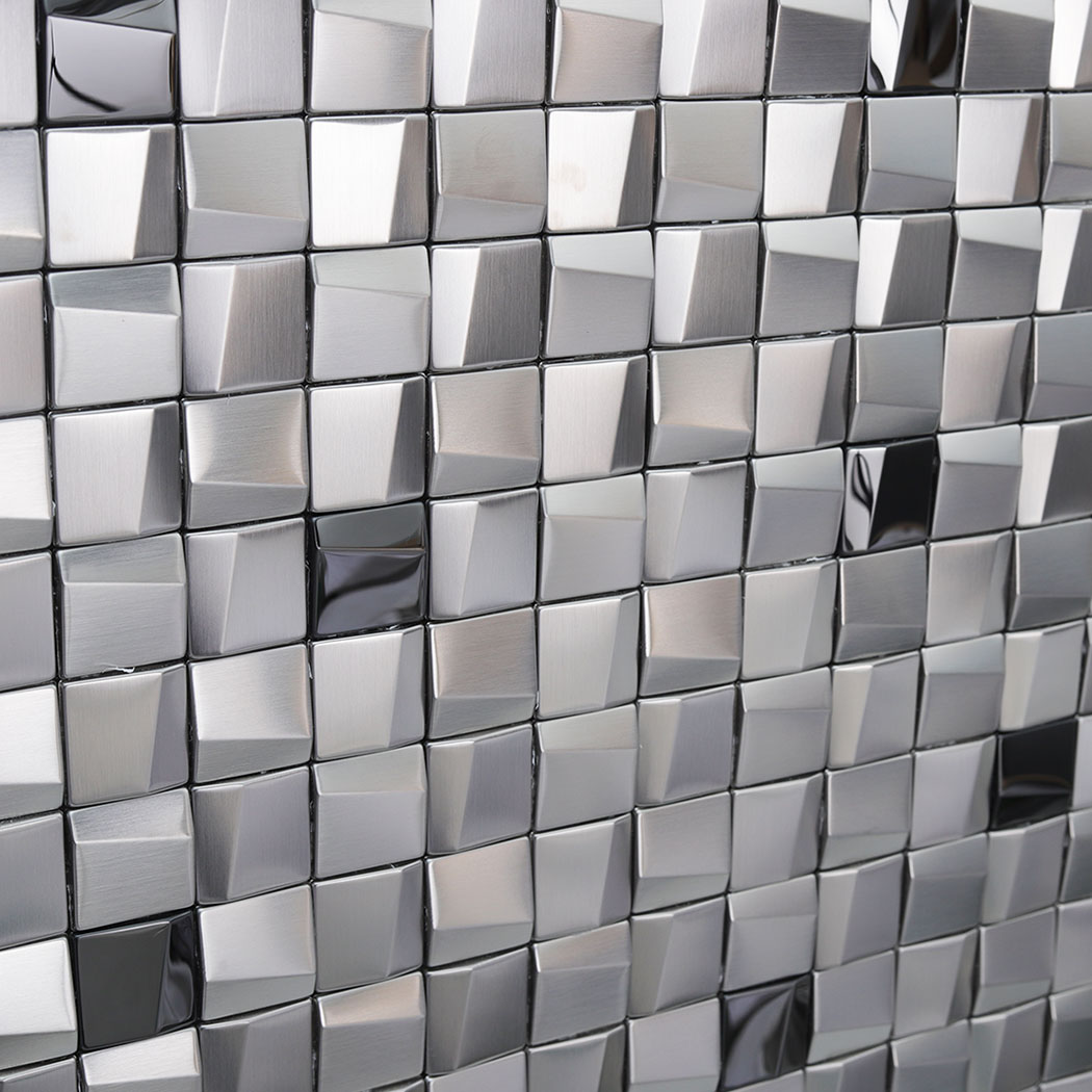 Angled close up of installed silver 3D square metal mosaic tiles reflecting light.