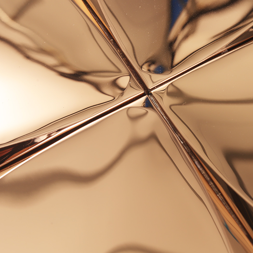 Close-up of the center point where four rose gold 3D wall tiles meet, highlighting the textures.