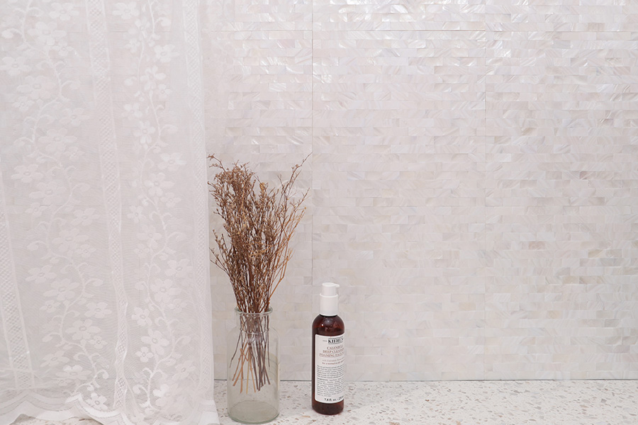 Luminous iridescent white shell mosaic tile backsplash, perfect for a luxury bathroom design.