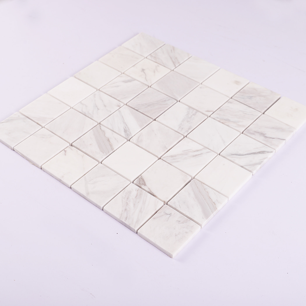 Angled perspective of Jazz White natural marble square mosaic tile sheet.