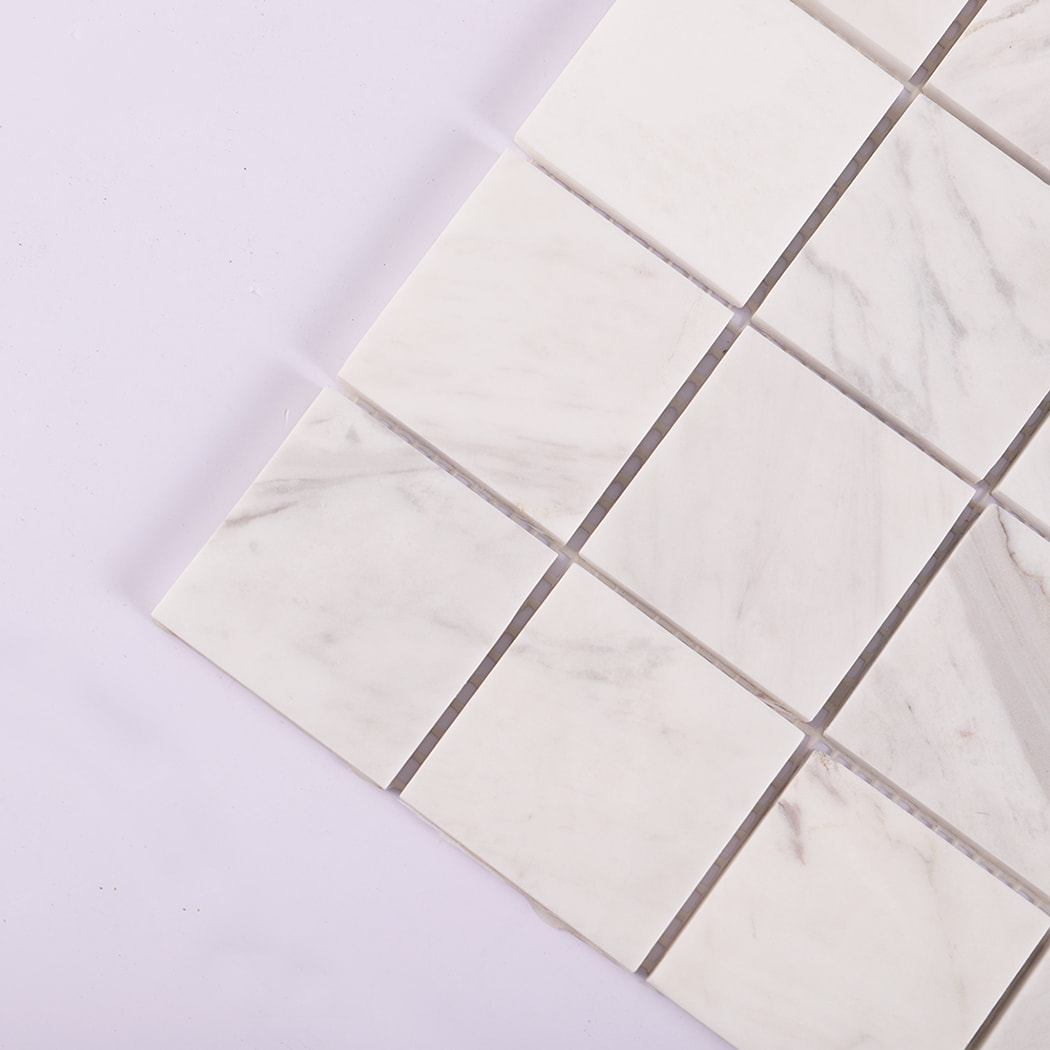Corner close-up showing the smooth surface of Jazz White marble mosaic tiles.