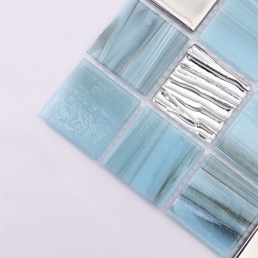 Close up of light blue mosaic tile corner with silver textured square