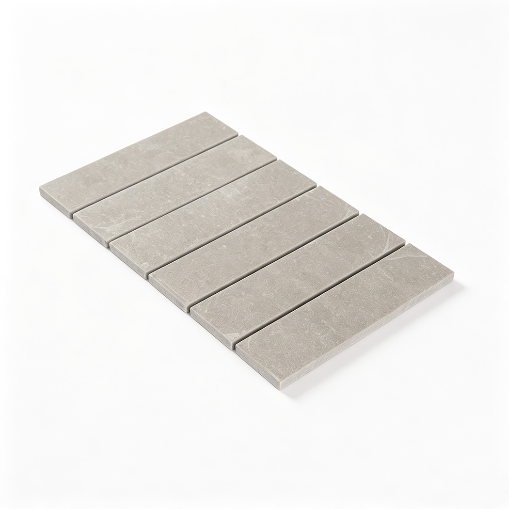 Angled view of a light gray linear marble mosaic sheet with subtle texture