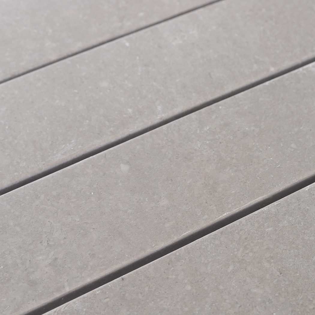 Detailed view of the smooth surface on light gray marble mosaic strips