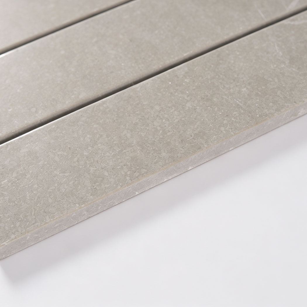 Angled close-up showing the surface and thickness of light gray marble strips