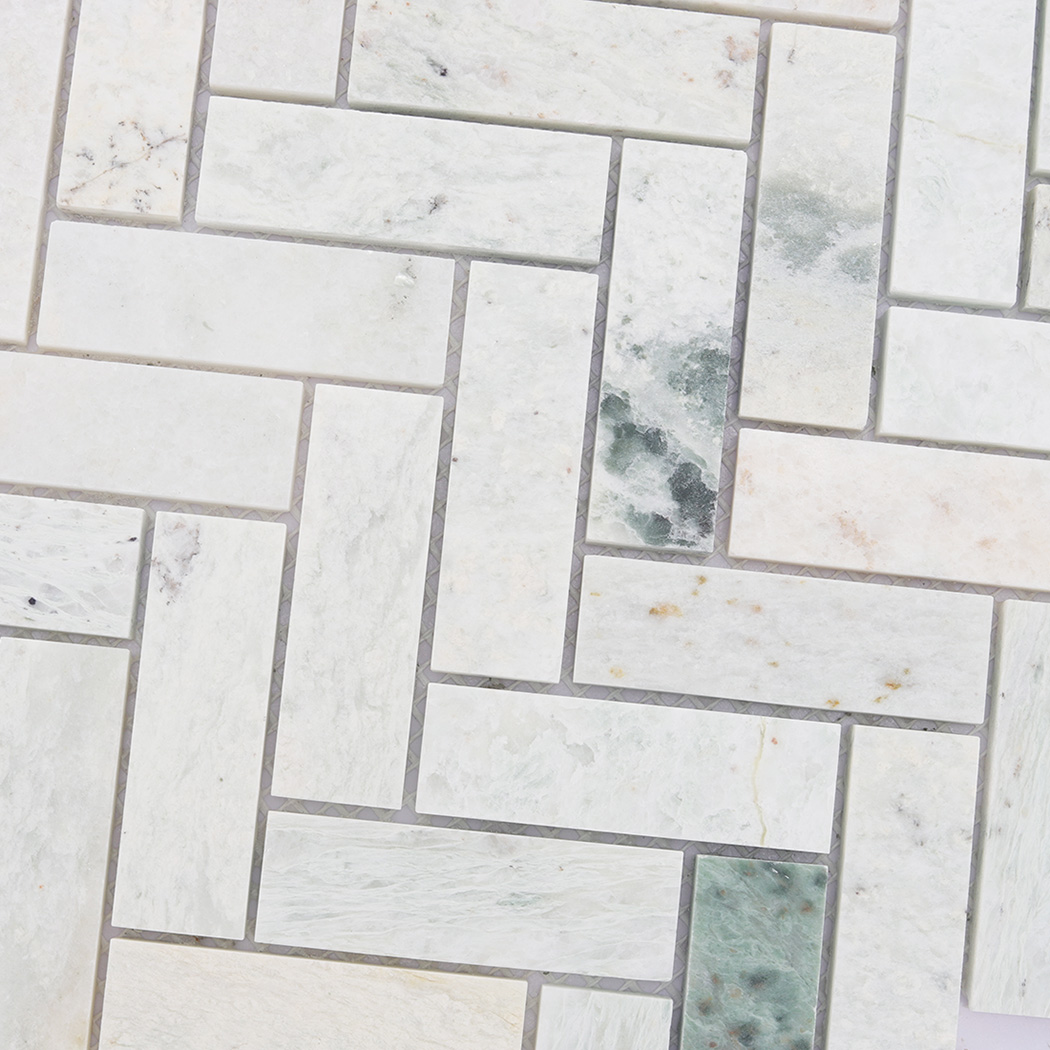 Surface detail of light green herringbone marble mosaic with natural veins