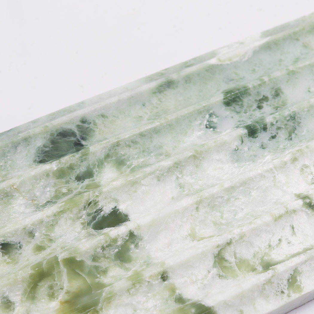 Close up of light green marble fluted tile with cloudy white veining