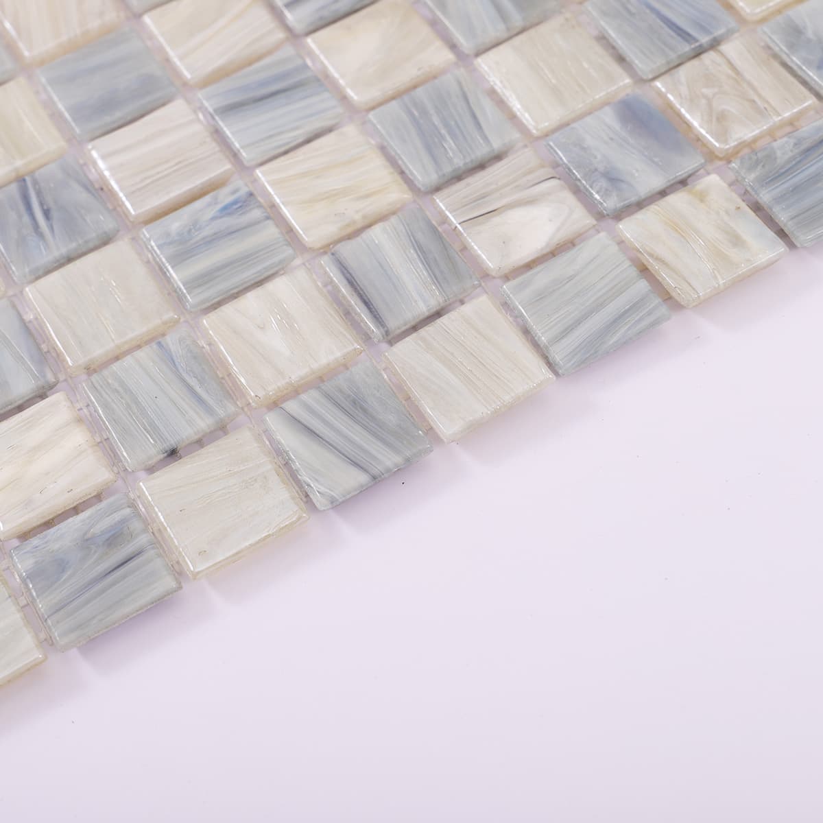 Edge detail of light grey and blue checkered glass mosaic tile