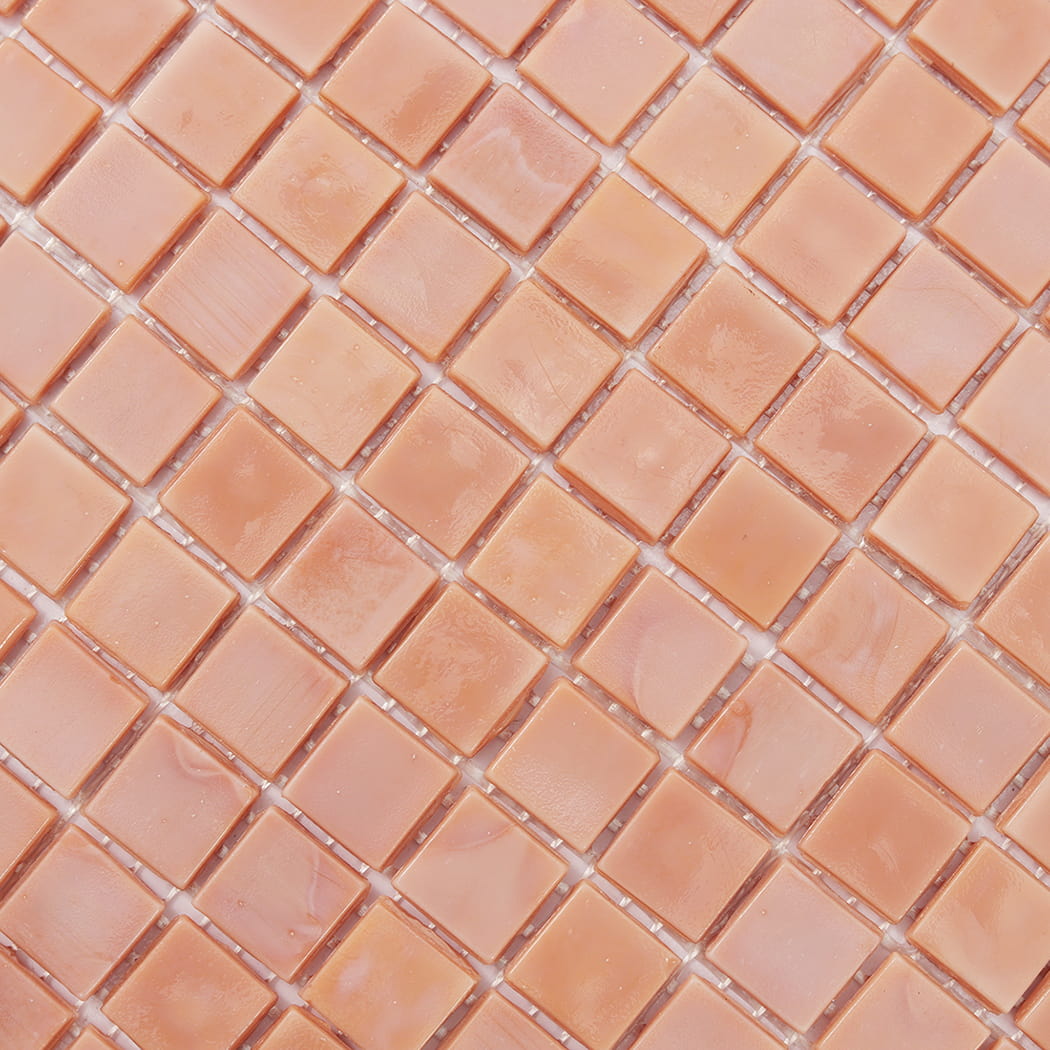 Close-up of light peach square glass mosaic tile surface and grout lines