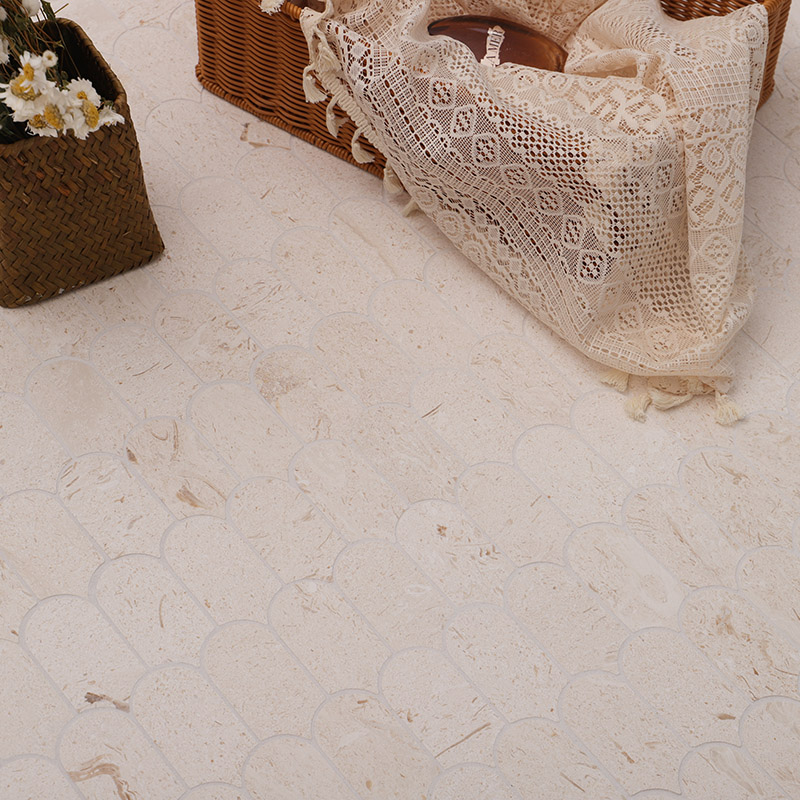 Close-up of cream limestone mosaic tiles showing natural texture and scalloped edges