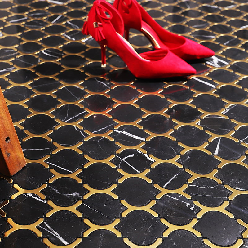 Side view of red heels on glossy black and gold arabesque marble floor