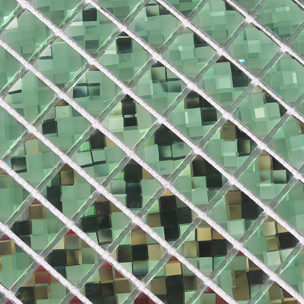 Macro detail of green mirror glass mosaic tiles showing intricate reflective facets.