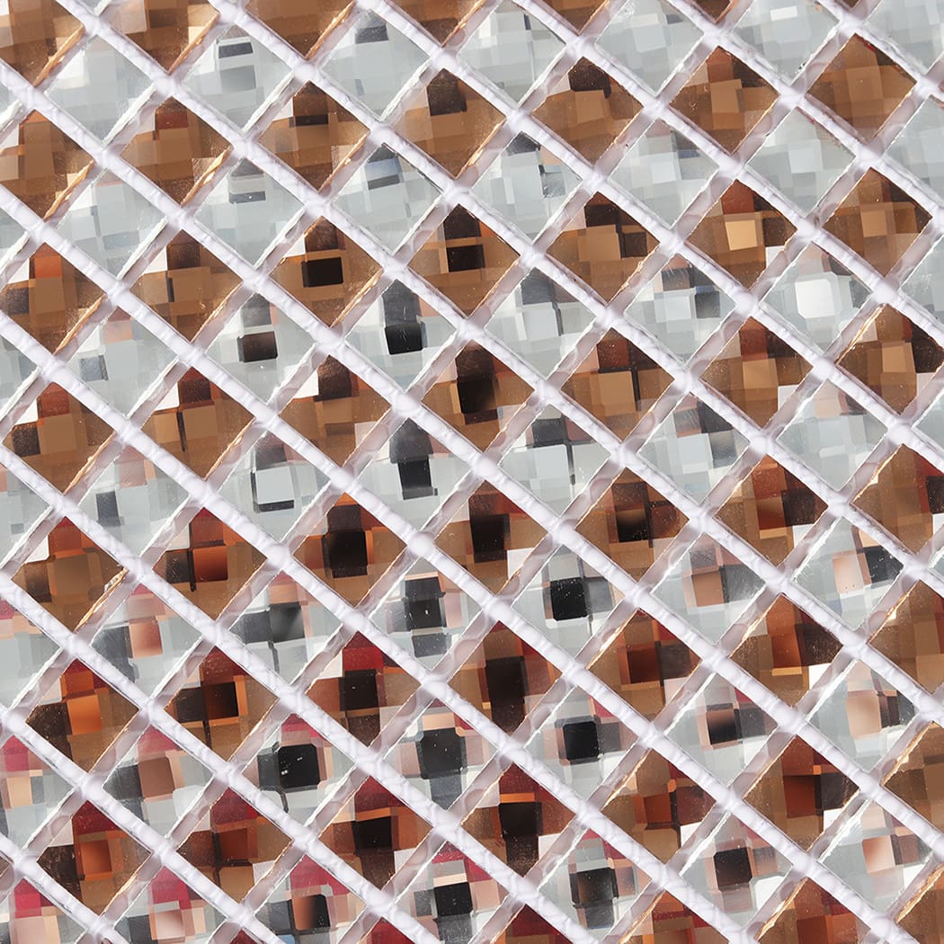 Macro detail of rose gold and silver diamond glass mosaic showing reflective surfaces.