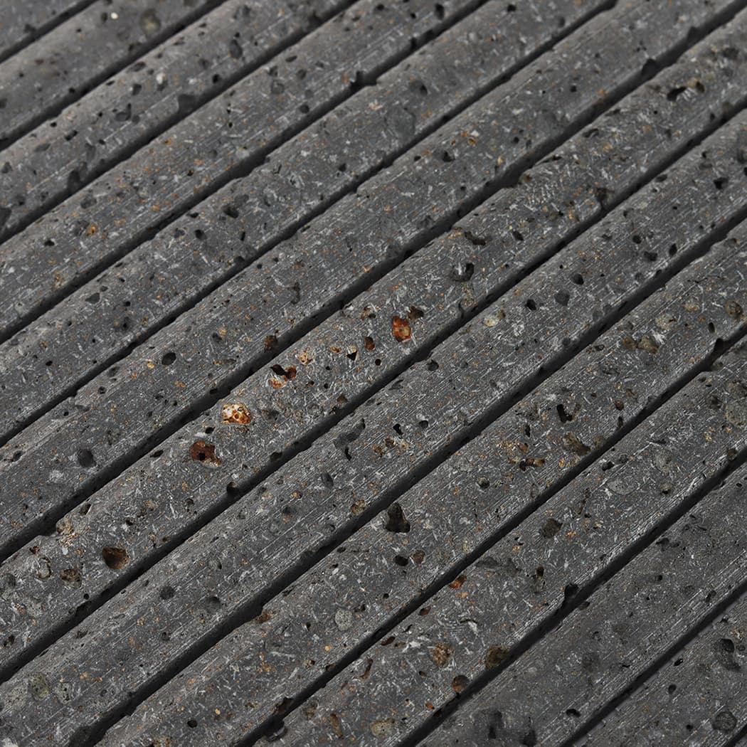 Macro view of the rounded fluted edges and volcanic pits on dark basalt kit kat tile.