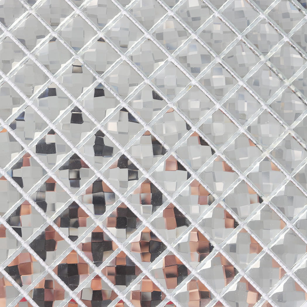 Macro detail of silver mirror glass mosaic tiles showing intricate reflective facets