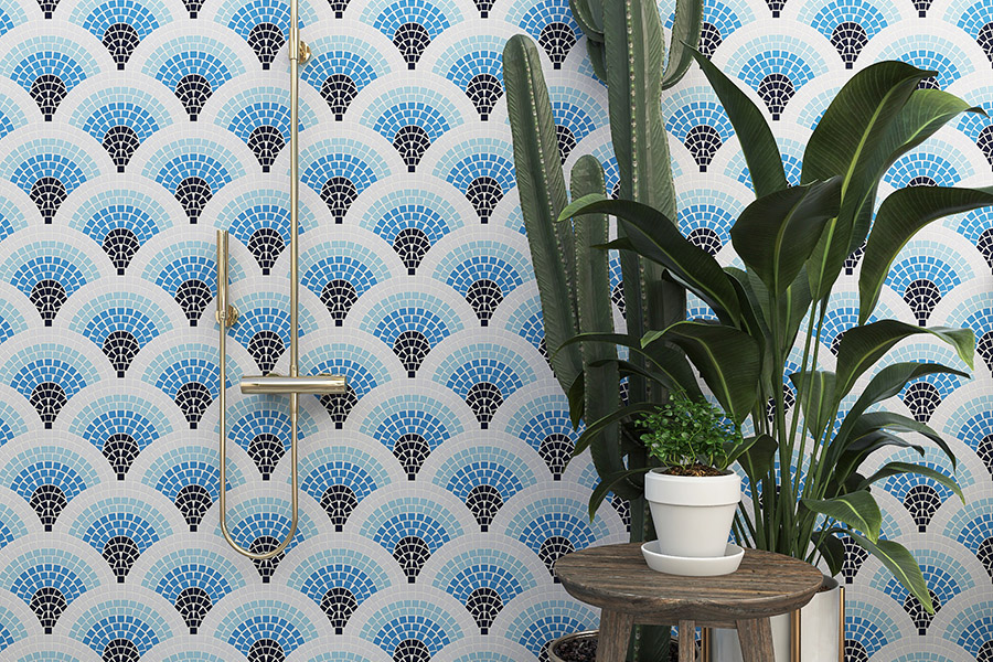 Blue and black fan mosaic tiles on a white bathroom wall with plants