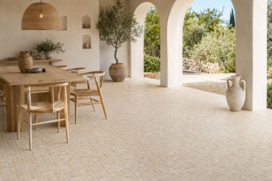 Mediterranean floor tiles in a sunlit arched dining patio with natural wood furniture