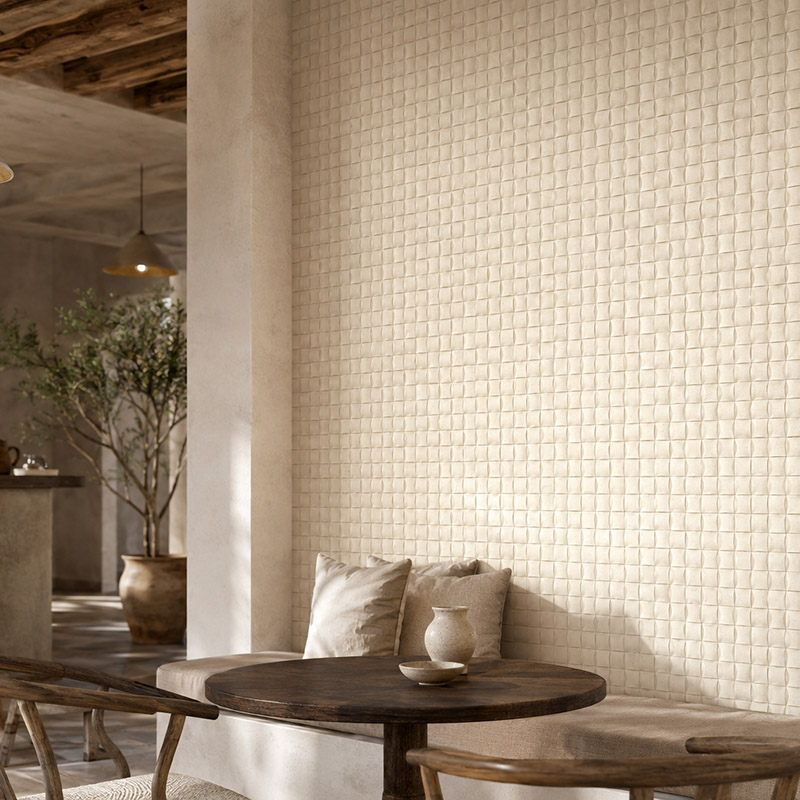 Close-up of cream Mediterranean wall tiles behind a cozy café seating area