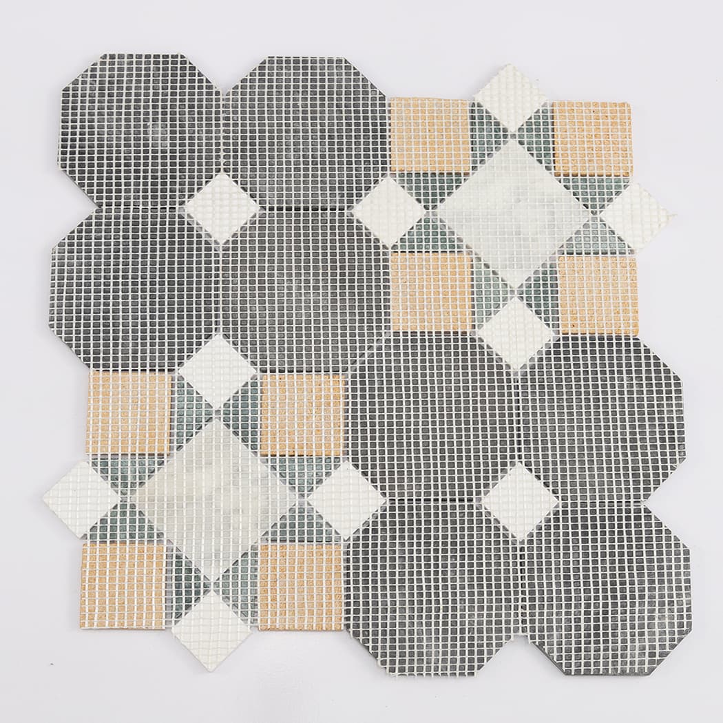 The reverse side of a marble mosaic tile sheet showing the white fiberglass mesh backing