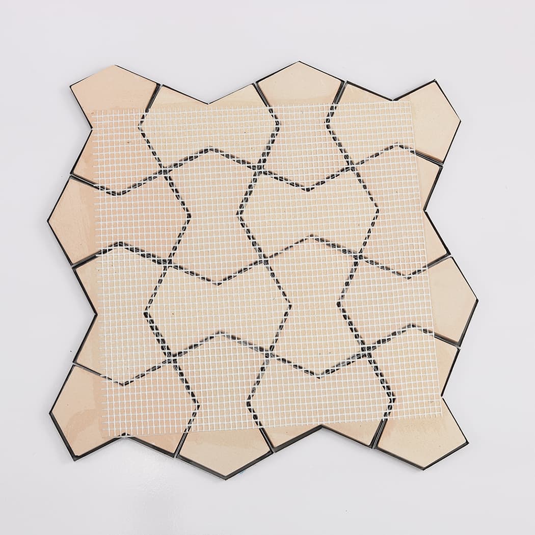 The back side of a 3D mosaic tile sheet showing the white mesh mounting system.
