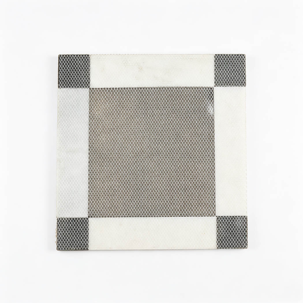 Back view of a black and white marble mosaic tile with mesh backing