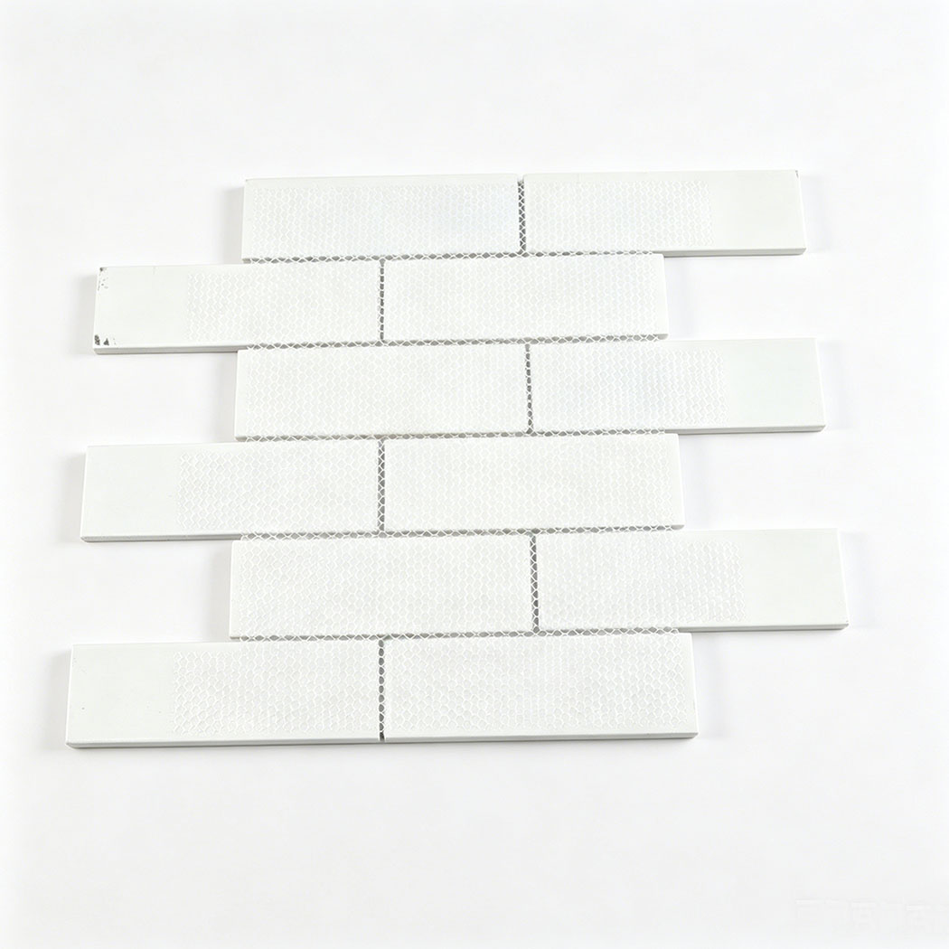 Back side of mesh mounted white glass subway tile sheet with staggered brick layout