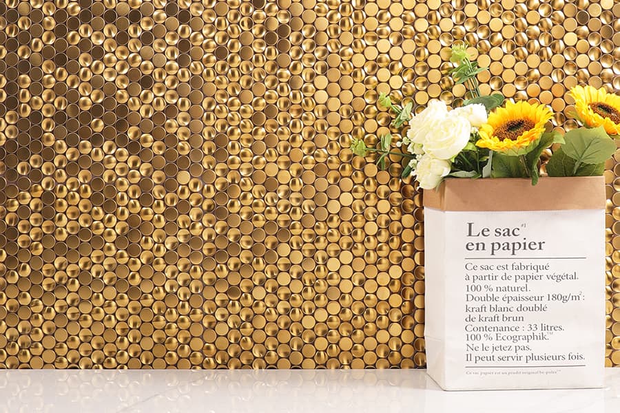 Golden metal penny round tile wall with sunflowers in paper bag